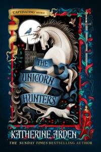 Book cover for The Unicorn Hunters by Katherine Arden. The intricate, medieval-tapestry-style illustration features a rearing white unicorn wrapped in a flowing blue banner that displays the book's title.